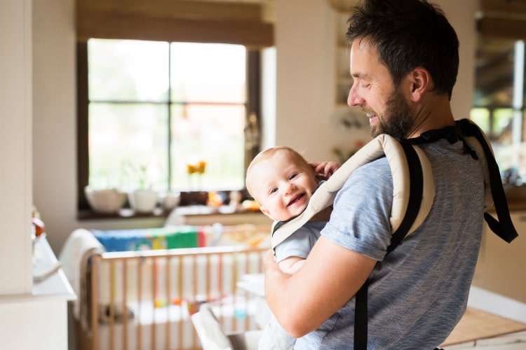 happy-father-with-baby-in-baby-carrier-at-home-2024-09-19-12-25-19-utc-min